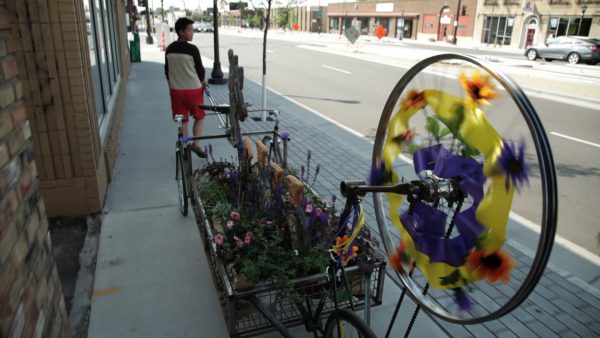 Bike-based mobile arts project carrying a full bed of flowers in motion