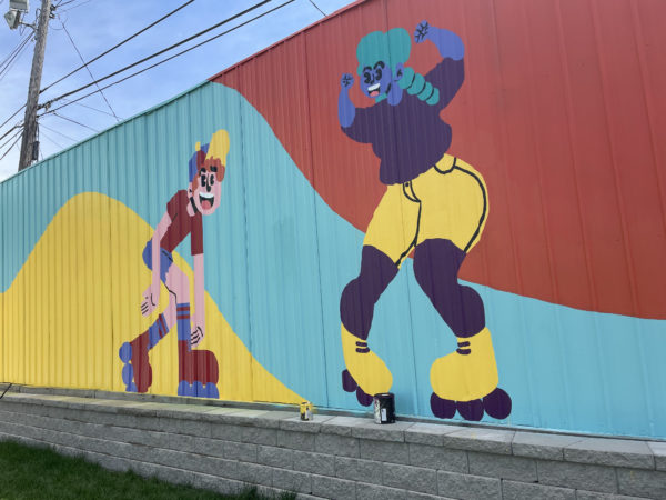 Colorful mural of a cartoon roller skater and dancer by Discover Dope