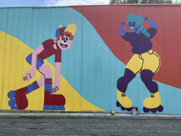 Colorful mural of a cartoon roller skater and dancer by Discover Dope