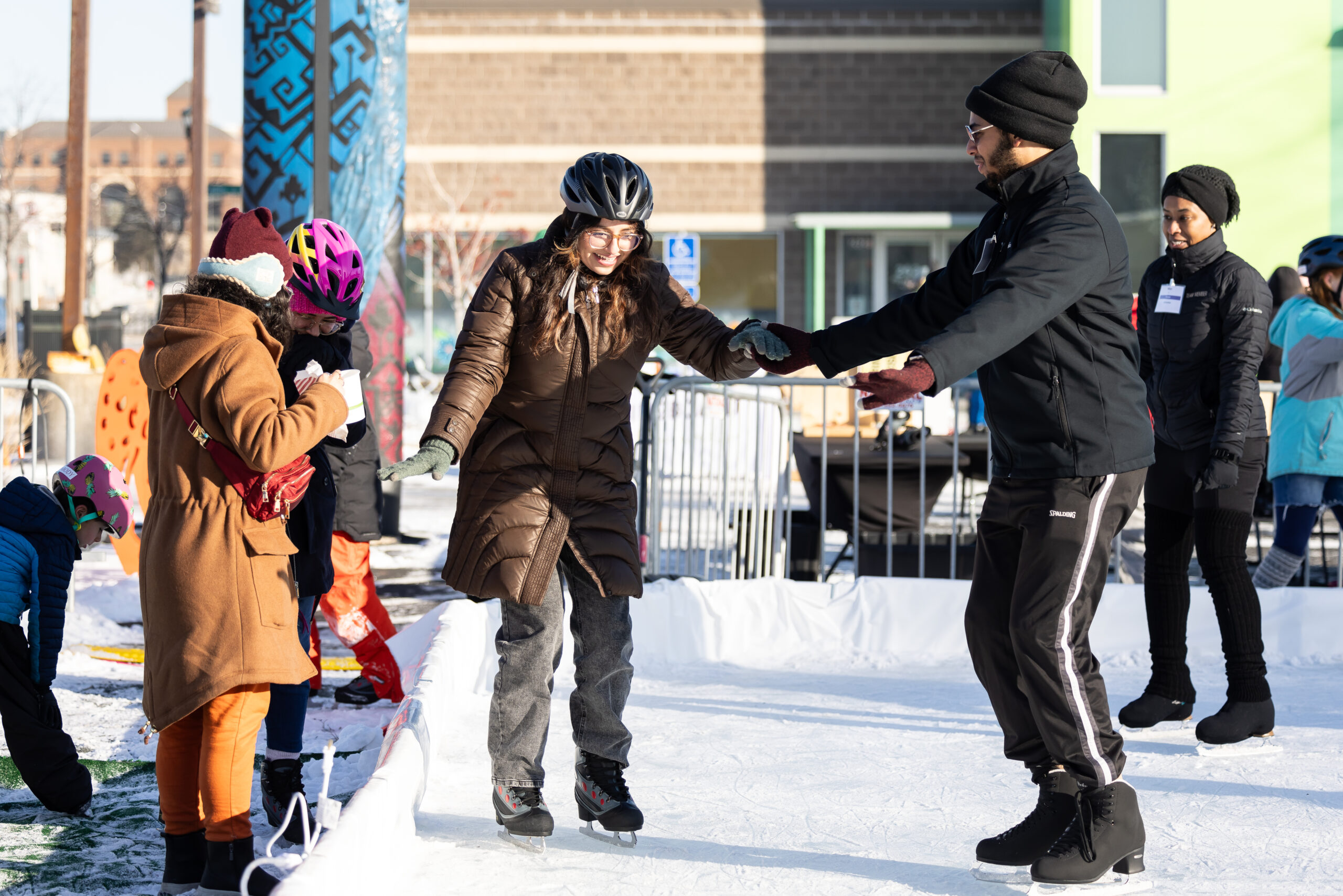 A Brownbody teaching artist facilitates a skating lesson art Springboard on Ice, 2024. 